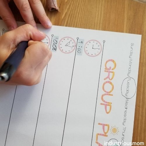 How to teach kindergarteners telling time, child drawing an analog clock on a group plan