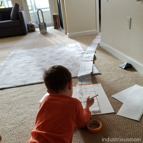 Boy creating a number roll Montessori work.